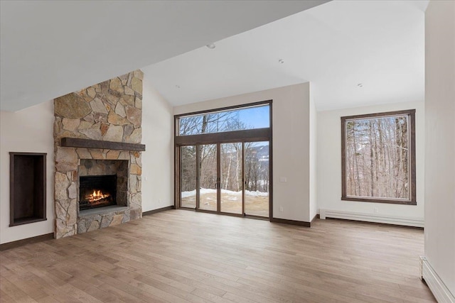 unfurnished living room with light hardwood / wood-style flooring, baseboard heating, high vaulted ceiling, and a fireplace