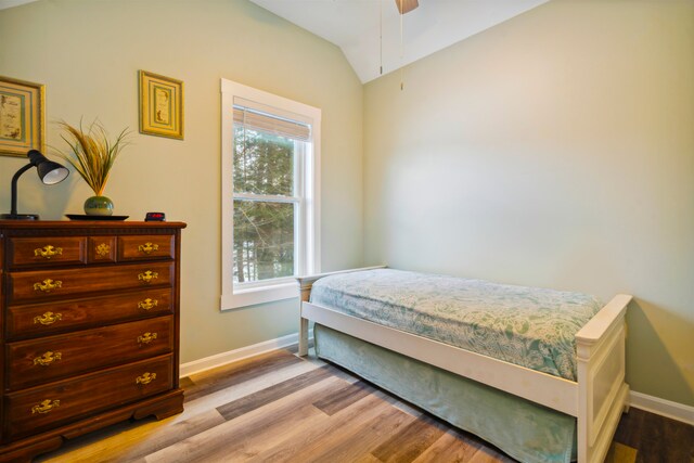 bedroom featuring light hardwood / wood-style floors, ceiling fan, and vaulted ceiling