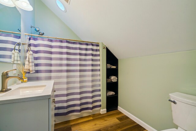 bathroom featuring lofted ceiling, oversized vanity, toilet, and wood-type flooring