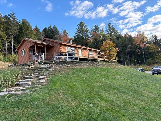 17 Tracy Hill Rd, Northfield, VT 05663 - view of front of home featuring a front yard, a wooden deck, and a wooded view