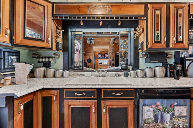 kitchen featuring sink, light stone countertops, and black dishwasher