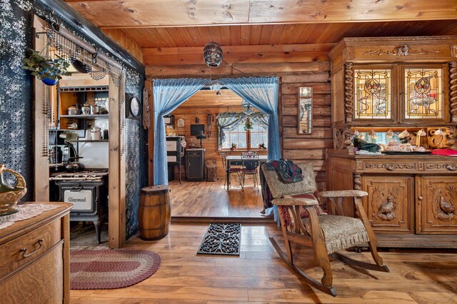 living area with wood ceiling, hardwood / wood-style flooring, and rustic walls