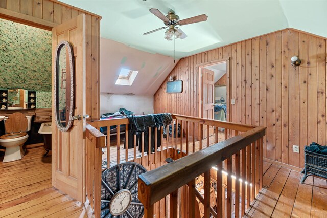 interior space featuring vaulted ceiling with skylight and light wood-type flooring