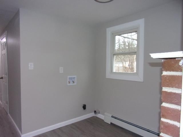 laundry area featuring dark hardwood / wood-style flooring, baseboard heating, and washer hookup