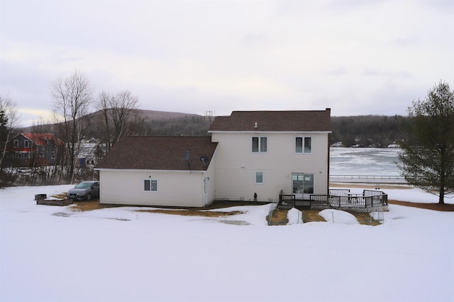 snow covered house with a wooden deck