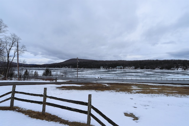 yard covered in snow with a rural view