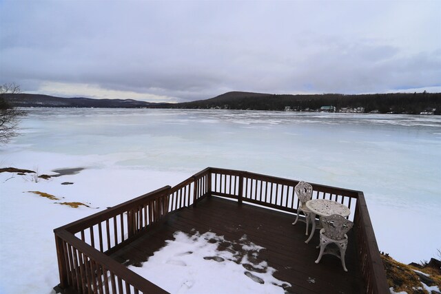 snow covered deck with a mountain view