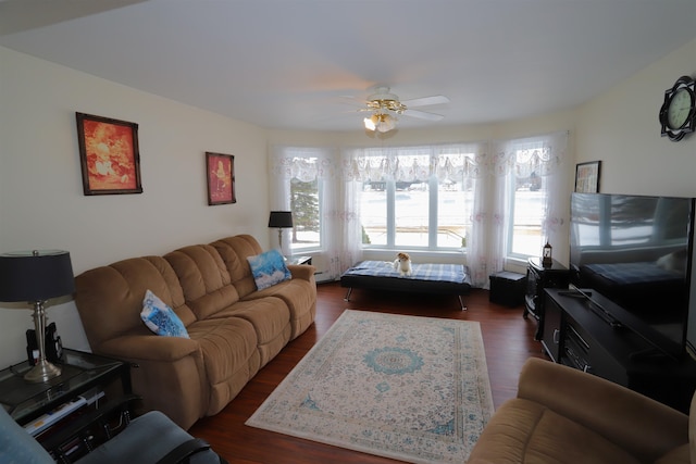 living room with dark wood-type flooring and ceiling fan