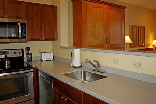kitchen with light countertops, appliances with stainless steel finishes, and a sink