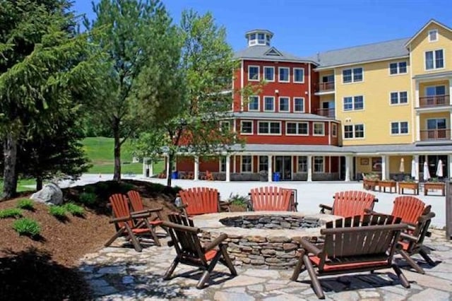 back of property with a fire pit and a patio area