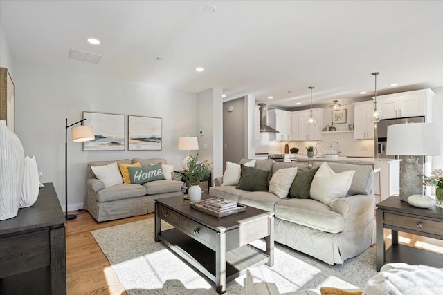 living room with light wood-type flooring and sink