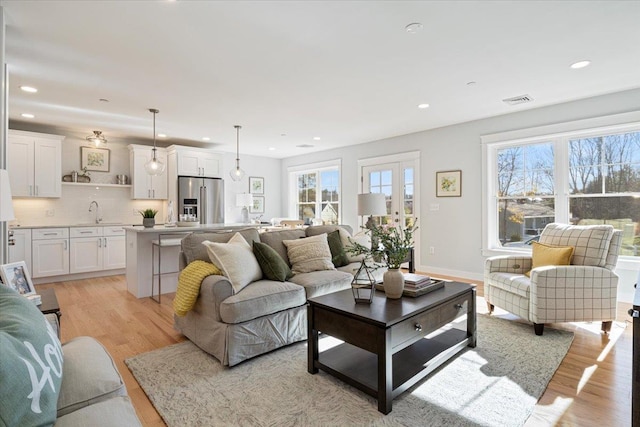 living room with sink and light hardwood / wood-style flooring