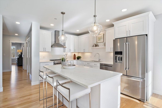 kitchen featuring white cabinetry, pendant lighting, wall chimney exhaust hood, and stainless steel appliances