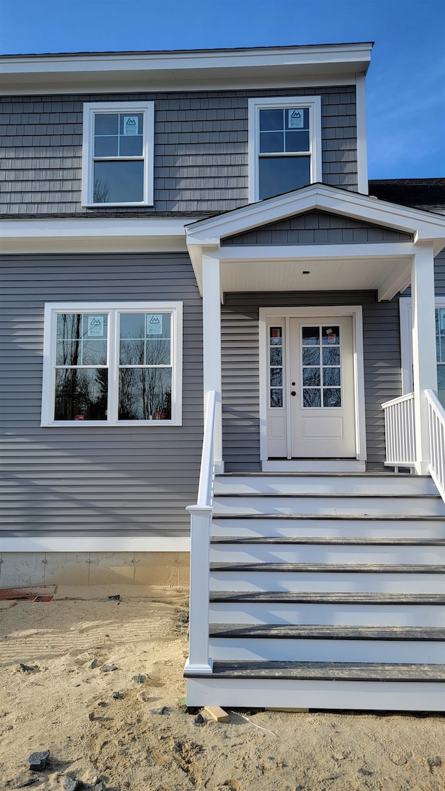 view of exterior entry featuring covered porch