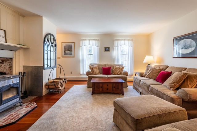 living room with baseboard heating, a wood stove, and dark hardwood / wood-style floors