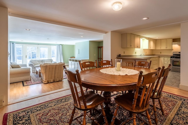 dining space featuring light wood-type flooring and sink