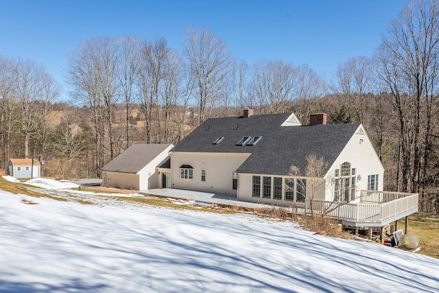 snow covered property with a deck