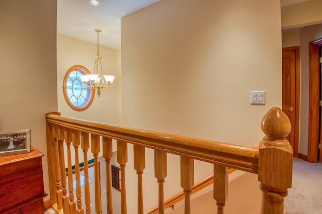 stairs with light carpet and a notable chandelier