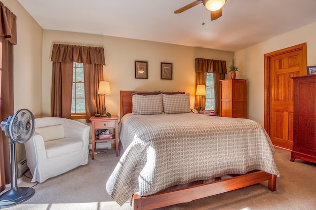 carpeted bedroom with ceiling fan and baseboard heating