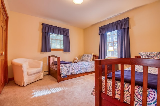 bedroom with light colored carpet and baseboard heating