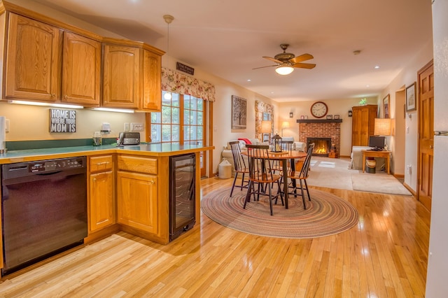 kitchen with ceiling fan, a brick fireplace, wine cooler, light hardwood / wood-style floors, and black dishwasher