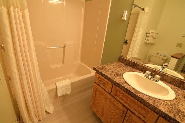 full bathroom featuring vanity with extensive cabinet space, shower / tub combo, and toilet