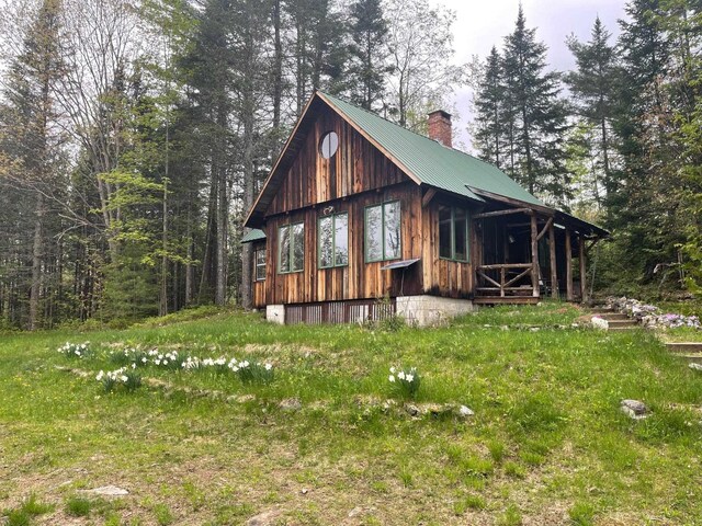 rear view of property with metal roof and a chimney