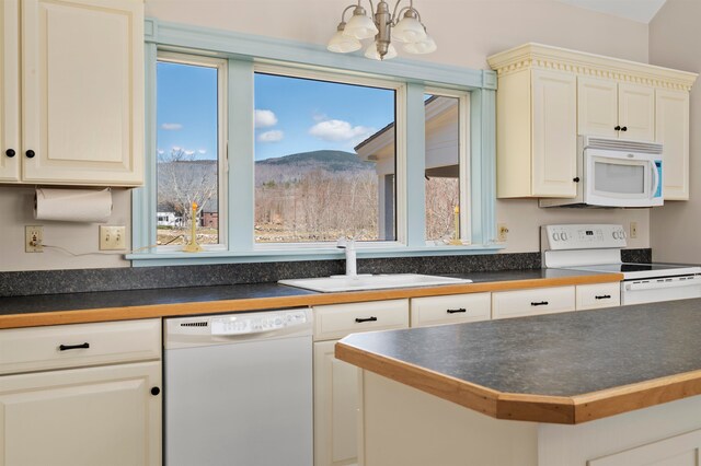 kitchen featuring a notable chandelier, decorative light fixtures, white appliances, and sink