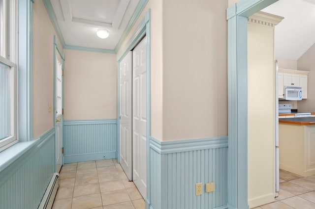hall featuring crown molding, light tile floors, and baseboard heating