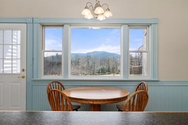 dining area with a healthy amount of sunlight, a mountain view, and a chandelier