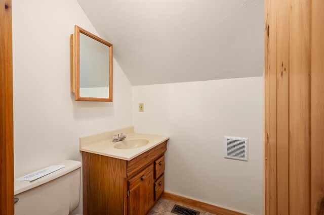 bathroom featuring lofted ceiling, vanity, toilet, and tile floors