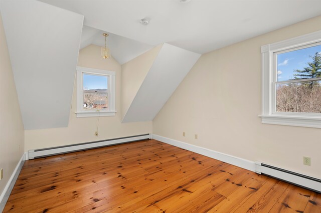 bonus room with wood-type flooring, a baseboard radiator, and vaulted ceiling
