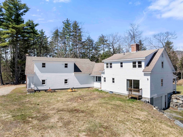 back of property with a garage and a lawn