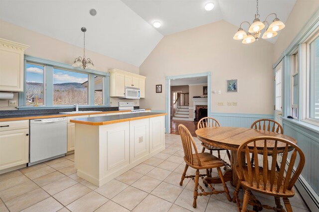 kitchen with hanging light fixtures, white appliances, a chandelier, and light tile floors