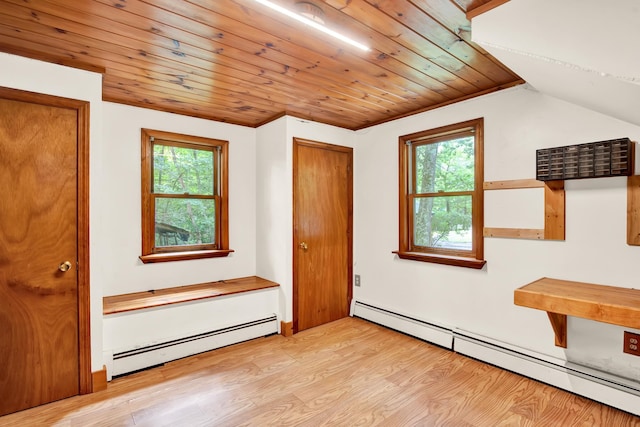 interior space with a wealth of natural light, a baseboard heating unit, and light hardwood / wood-style floors