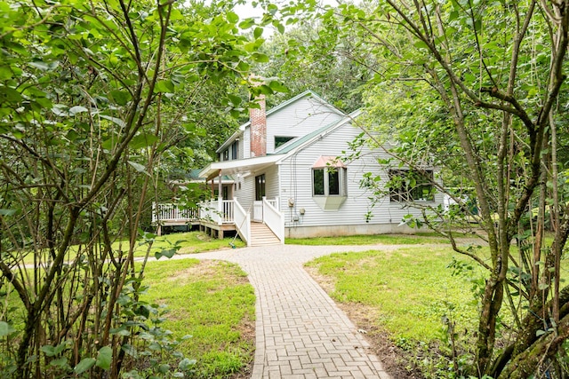 view of front facade with a front lawn and a wooden deck