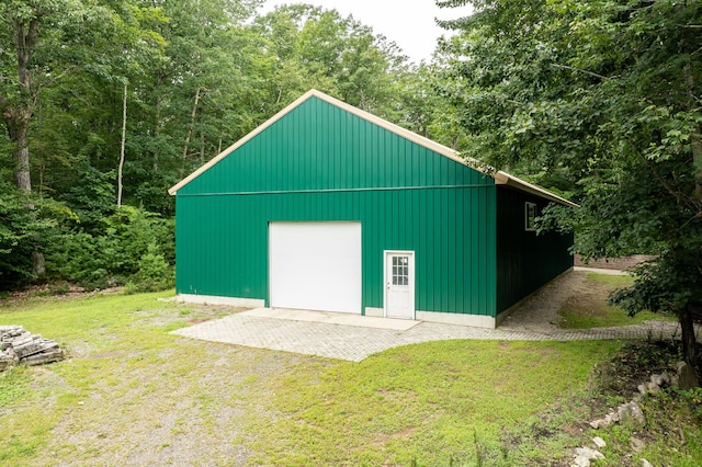 view of shed / structure featuring a garage and a lawn