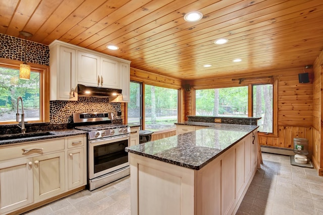 kitchen featuring stainless steel gas range oven, backsplash, a baseboard radiator, sink, and light tile floors