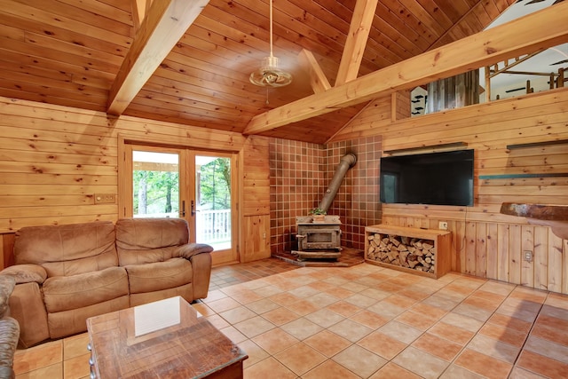 unfurnished living room featuring wooden walls, a wood stove, tile floors, and beam ceiling