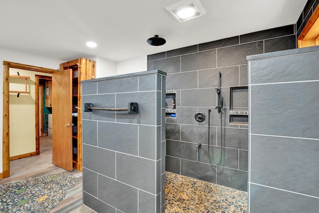 bathroom featuring tile floors and a tile shower