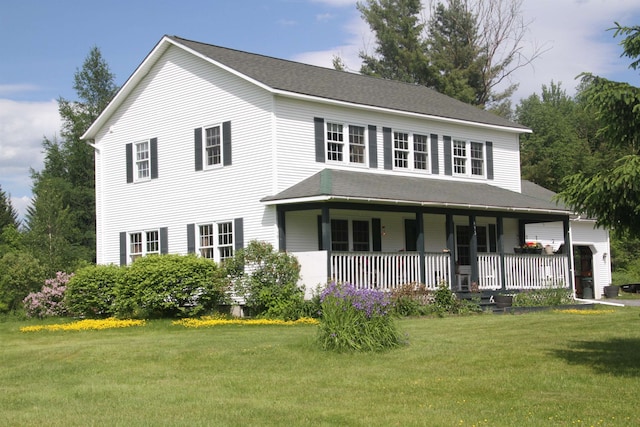 view of front of home with a front yard and covered porch