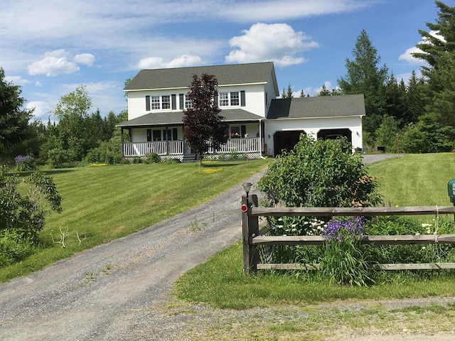 view of front of property with a garage, a front lawn, and covered porch