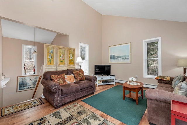 living room with hardwood / wood-style floors, vaulted ceiling, and a baseboard heating unit