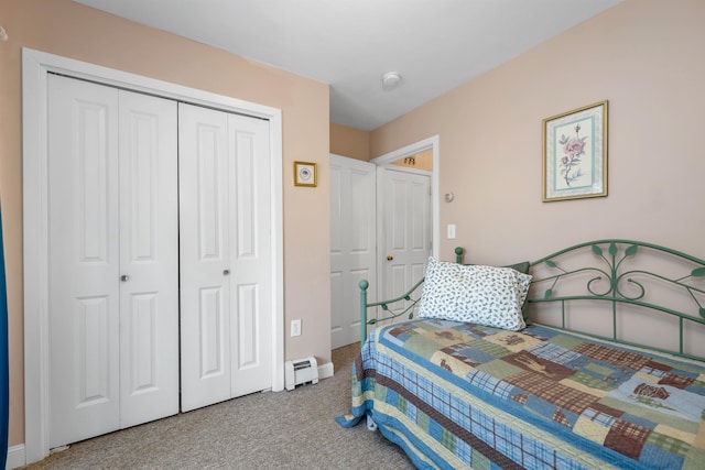 carpeted bedroom featuring a baseboard heating unit and a closet