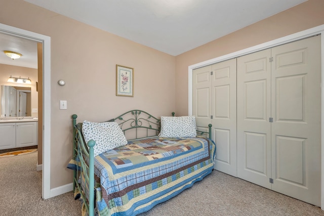 carpeted bedroom featuring a closet and ensuite bathroom