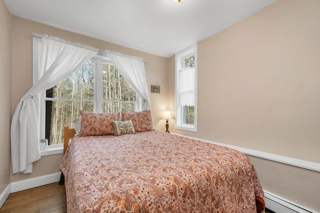 bedroom with wood-type flooring and baseboard heating