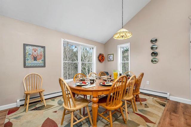 dining area with lofted ceiling, hardwood / wood-style flooring, and baseboard heating