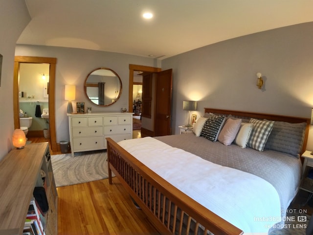 bedroom featuring connected bathroom and hardwood / wood-style flooring