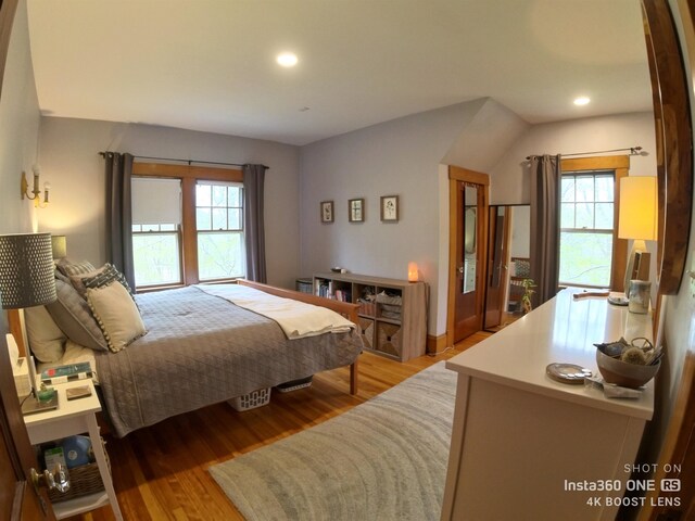 bedroom featuring multiple windows and light hardwood / wood-style flooring