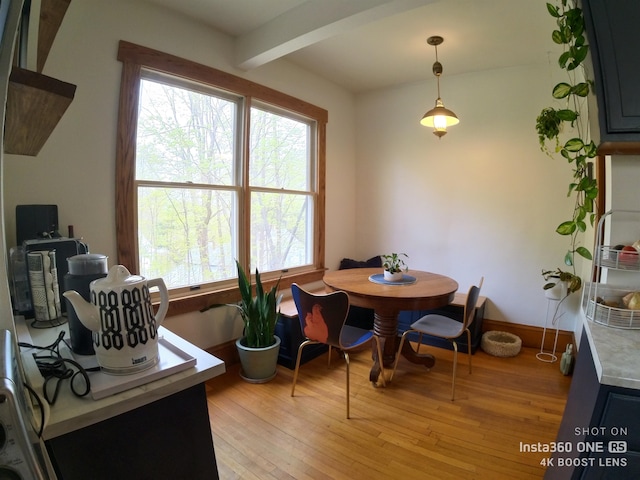 dining area with beam ceiling and light wood-type flooring